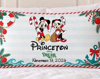 May include: A rectangular pillowcase with a light blue and white striped background featuring Mickey and Minnie Mouse in Santa hats, candy canes, a life preserver, and an anchor. Text reads Princeton, Disney Dream, and November 13, 2026.