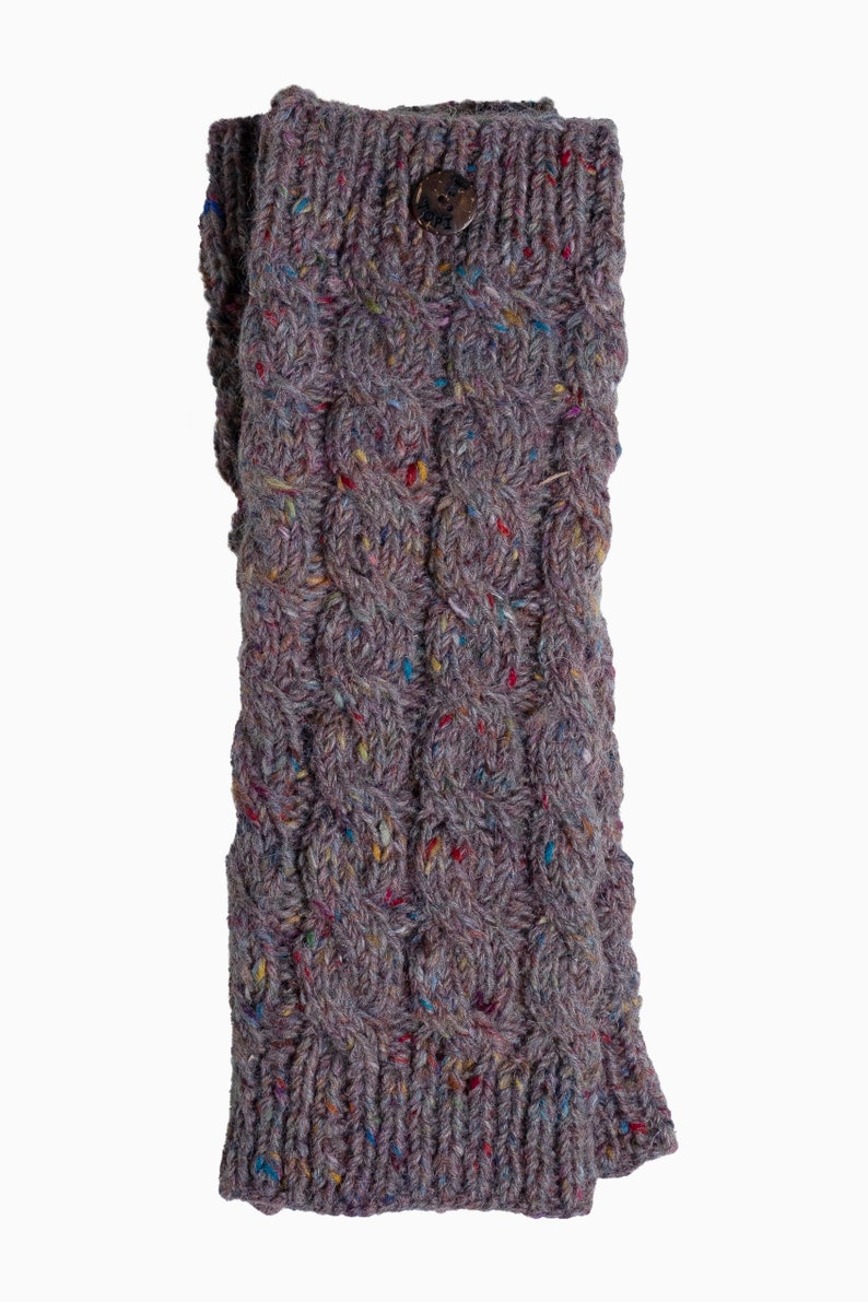 May include: A gray knitted leg warmer with a cable knit design and a wooden button closure. The leg warmer is made of a speckled yarn with flecks of color.