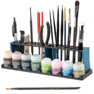 Peut inclure: Un organisateur de peinture et d'outils en plastique bleu avec 20 fentes. L'organisateur est rempli de divers flacons de peinture et outils, notamment des pinceaux, des pinces et des pinces. L'organisateur est posé sur une surface blanche.