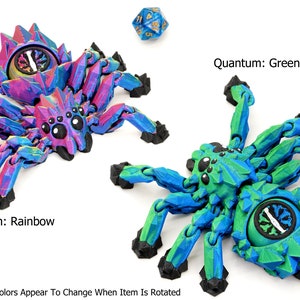 May include: Two 3D printed spider figurines with articulated legs. The spider on the left is a rainbow color that shifts when rotated. The spider on the right is green and blue. Both spiders have a black eye design and a round, black, segmented body.