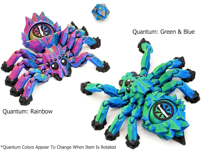 May include: Two 3D printed spider figurines with articulated legs. The spider on the left is a rainbow color that shifts when rotated. The spider on the right is green and blue. Both spiders have a black eye design and a round, black, segmented body.