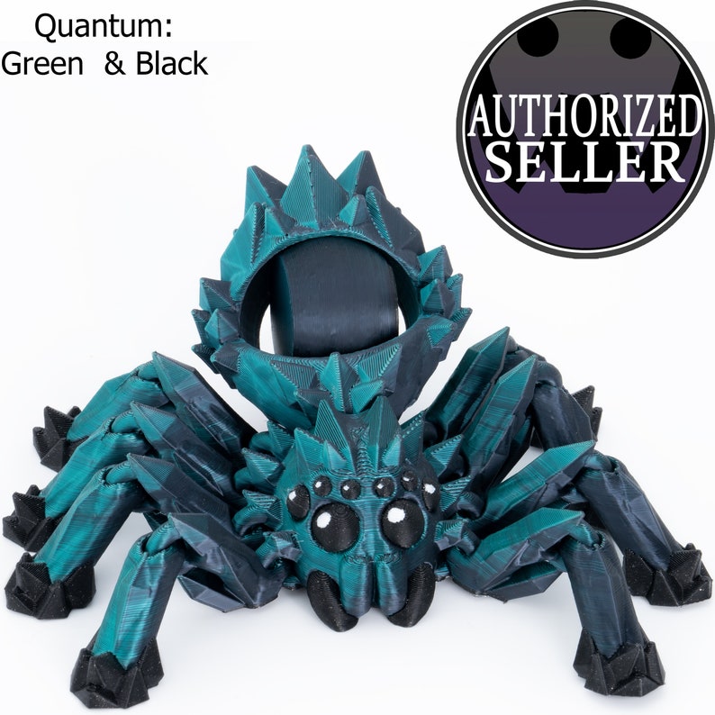 May include: A teal and black 3D printed spider with a spiky, crystal-like design. The spider has large, black eyes and a detailed, textured body.