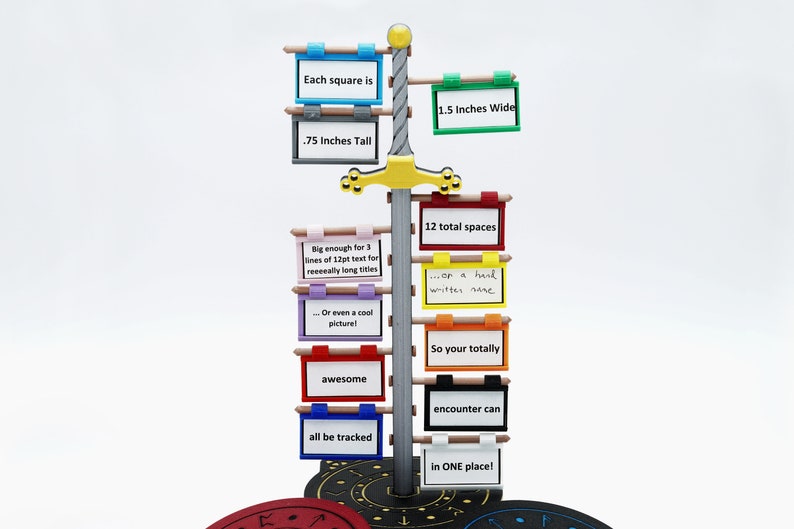 K&ouml;nnte beinhalten: Ein silbernes Schwert mit gelbem Griff und schwarzem Sockel. Das Schwert h&auml;lt 12 bunte quadratische Schilder mit Text darauf. Die Schilder sind 3,8 cm breit und 1,9 cm hoch. Der Text auf den Schildern lautet: "Each square is", "1.5 Inches Wide", ".75 Inches Tall", "Big enough for 3 lines of 12pt text for reeeally long titles", "Or even a cool picture!", "12 total spaces", "...or a hand written name", "So your totally awesome", "encounter can", "all be tracked", "in ONE place!"