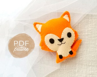 May include: PDF pattern for a felt fox toy. The fox is orange with white facial features and black eyes. The toy is on a white background.