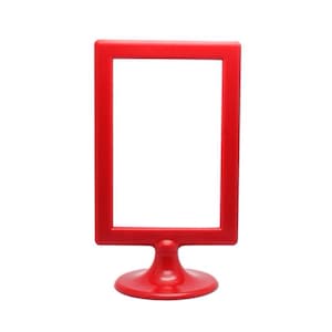 May include: A bright red, rectangular tabletop sign holder with a rounded base. The frame is empty, ready for a sign or display. The sign holder is made of plastic and is designed to stand upright.