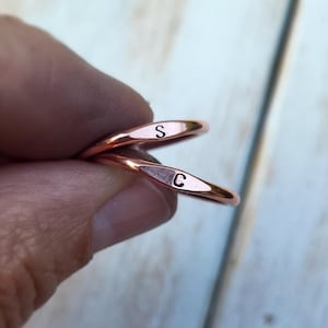 May include: Two copper rings with the letters "S" and "C" engraved on them.