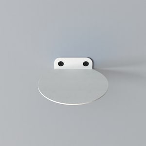 May include: White metal shelf with a rounded edge, mounted to a wall with two black screws.