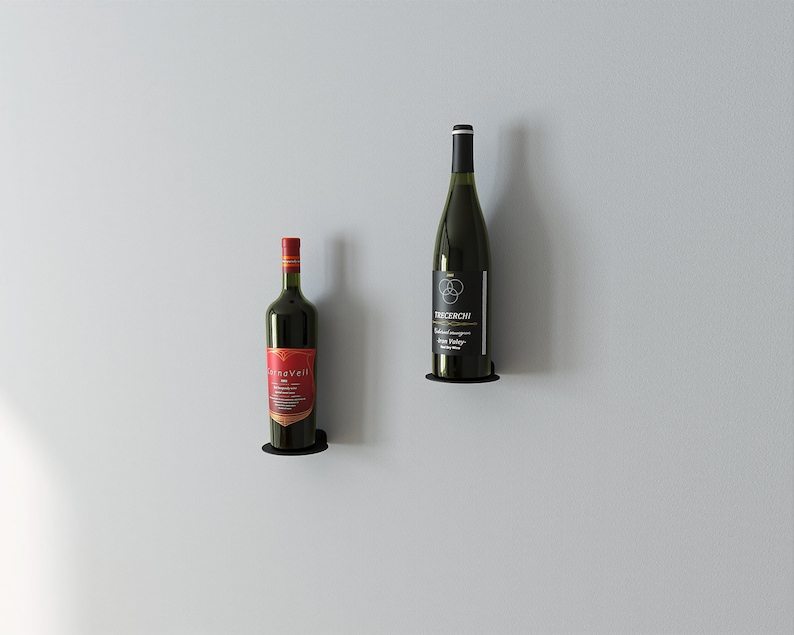 May include: Two bottles of wine mounted on a wall with black metal holders. The bottle on the left is red wine with a gold label that says "Silverveil". The bottle on the right is white wine with a black label that says "TRACEROW" and "Sonoma Valley".