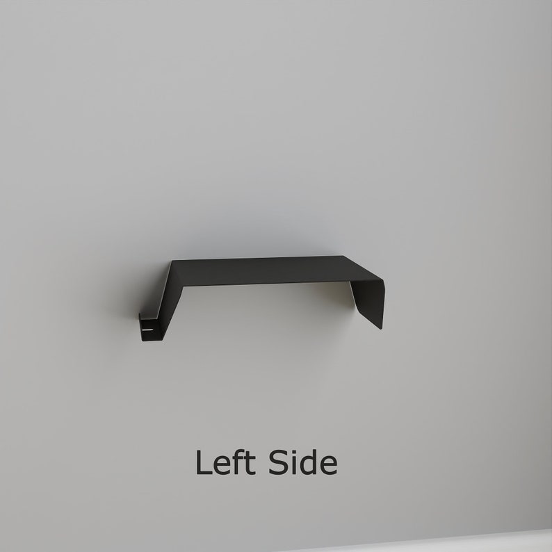 A black metal shelf with a minimalist design. The shelf is mounted on a light gray wall. The text "Left Side" is displayed below the shelf.