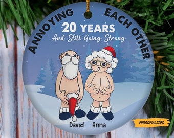 May include: A blue and white Christmas bauble featuring a cartoon couple, a man and a woman, with the text "Annoying Each Other 20 Years And Still Going Strong". The bauble is personalised with the names "David" and "Anna".
