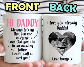 May include: White ceramic mug with the text "HI DADDY" in pink on the front, along with a message from the mother. The back of the mug features the text "I love you already Daddy!" and a sonogram image inside a heart. A perfect gift for a new dad.