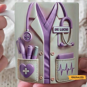 May include: A white ceramic mug featuring a doctor's coat design with a purple stethoscope, pens, and a heart-shaped pocket. The mug has the text "DR LUCIA" and a personalized label.