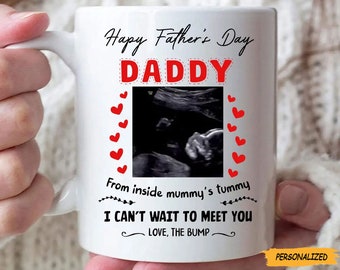 May include: White ceramic mug with the text "Happy Father's Day DADDY" in black and red. The mug features a sonogram image and the phrases "From inside mummy's tummy" and "I CAN'T WAIT TO MEET YOU LOVE, THE BUMP".