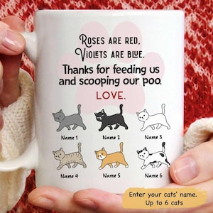 May include: White ceramic mug with a cat-themed design. The mug features six cartoon cat illustrations and the text "Roses are red, violets are blue. Thanks for feeding us and scooping our poo. LOVE." The bottom of the mug says "Enter your cats' name. Up to 6 cats."