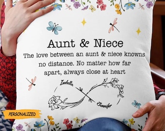 May include: Square white cushion with floral and butterfly designs. Text reads "Aunt & Niece" with a personalized message and names "Isabella" and "Jennifer". The cushion has a "PERSONALIZED" label.