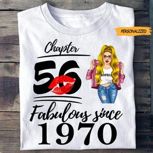 Peut inclure: T-shirt blanc avec le texte "Chapter 56 Fabulous since 1970". Comprend un grand "56" noir avec une marque de baiser rouge et une illustration de femme avec le nom "Sophia".