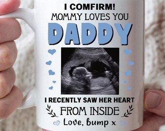 May include: White ceramic mug with the text "I CONFIRM! MOMMY LOVES YOU DADDY" in black and blue. Includes a sonogram image and the text "I RECENTLY SAW HER HEART FROM INSIDE Love, bump x".