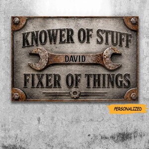 May include: A rectangular metal sign with a weathered finish featuring the text "KNOWER OF STUFF" at the top, "DAVID" in the center on a wrench graphic, and "FIXER OF THINGS" at the bottom. The sign has four corner bolts and a gear icon.