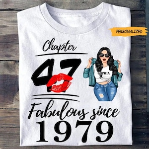 May include: White t-shirt with the text "Chapter 47 Fabulous since 1979". The design includes a large black "47" with a red lip graphic, and a cartoon illustration of a woman wearing sunglasses and a denim jacket. The word "PERSONALIZED" is in a yellow banner.