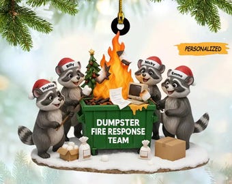 May include: A personalized Christmas ornament featuring five raccoons wearing Santa hats around a green dumpster fire. The ornament has the text "DUMPSTER FIRE RESPONSE TEAM" and the word "PERSONALIZED". The ornament is hanging from a gold string.