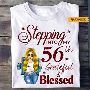 Peut inclure: T-shirt blanc avec un motif « Stepping into my 56th Grateful & Blessed ». Le motif comprend une femme de dessin animé aux cheveux blonds et lunettes de soleil. Le chiffre 56 est dans un motif à carreaux rouges. Le mot « Personnalisé » est dans une bannière jaune.