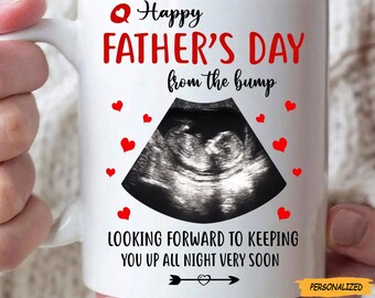 May include: White ceramic mug with the text "Happy Father's Day from the bump" in red and black. The mug features a sonogram image and red heart graphics. The bottom of the mug reads "Looking forward to keeping you up all night very soon."