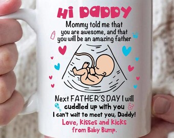 May include: White ceramic mug with the text "Hi pappy" in pink. The mug features a baby ultrasound graphic and text that reads "Next FATHER'S DAY I will cuddled up with you".