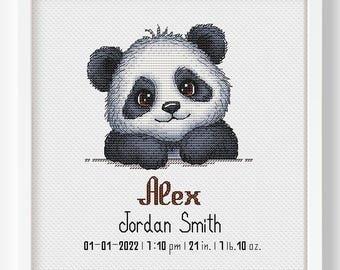 May include: A framed cross-stitch featuring a cute panda bear with black and white fur. The panda is above the text "Alex Jordan Smith" and birth details: 01-01-2022, 1:10 pm, 21 inches, 11 lbs, 10 oz. The artwork is in a white frame.