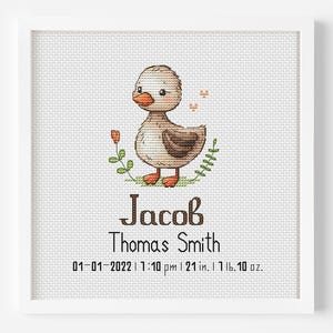 May include: A white frame with a light brown duckling illustration and the name Jacob, Thomas Smith, and the date 01-01-2022, 1:10 pm, 21 in., 1 lb. 10 oz.