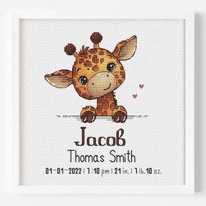 Puede incluir: Un marco blanco con un diseño de punto de cruz de una linda jirafa con manchas marrones. La jirafa está mirando por encima de un borde blanco. El texto "Jacob Thomas Smith 01-01-2022 | 1:10 pm | 21 in. | 1 lb. 10 oz." está debajo de la jirafa.