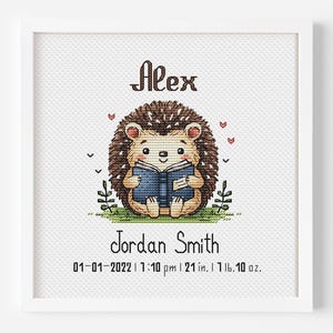 Puede incluir: Un bordado de punto de cruz enmarcado con un lindo erizo leyendo un libro. El erizo es marrón y beige, con un libro azul. El nombre "Alex" está encima del erizo, y "Jordan Smith" debajo. También se incluye la fecha, la hora, la altura (53 cm) y el peso (737 g).