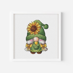 May include: A green gnome with a white beard and a sunflower hat. The gnome is wearing a green and yellow outfit and has a yellow bow on its head.