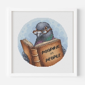 Peut inclure: Illustration au point de croix d'un pigeon portant des lunettes, lisant un livre avec le texte "Pooping on People". Le pigeon est placé sur un fond circulaire bleu clair, encadré dans un cadre carré blanc.