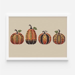以下が含まれることがあります： オレンジ、茶色、黒の色の異なる模様が施された、装飾用のカボチャが4つ。カボチャはベージュの背景に一列に並んでいます。