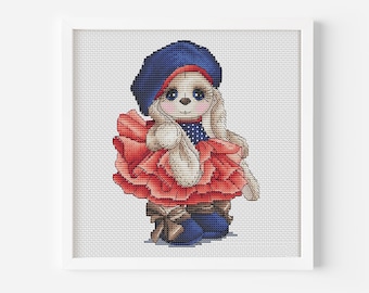 May include: A cross-stitch pattern of a cute bunny wearing a blue beret and a red ruffled dress. The bunny is holding a white stuffed animal.