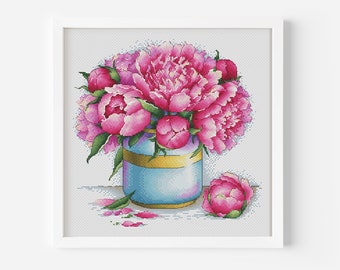 May include: A bouquet of pink peonies in a blue and gold vase with a single pink peony bud on the table.