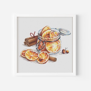 Puede incluir: Un tarro de vidrio lleno de rodajas de naranja secas y palitos de canela. El tarro tiene una tapa y está atado con una cinta roja. También hay algunas rodajas de naranja y palitos de canela esparcidos alrededor del tarro.