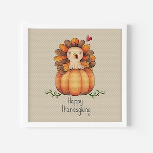 Pode incluir: Padrão de ponto cruz com um peru de desenho animado fofo sentado dentro de uma abóbora com o texto "Feliz Dia de Ação de Graças".