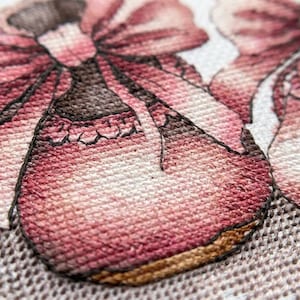 May include: Close-up of two embroidered baby shoes in shades of pink and brown. Each shoe has a large bow and decorative trim. The shoes are set against a white background with a delicate lace pattern.