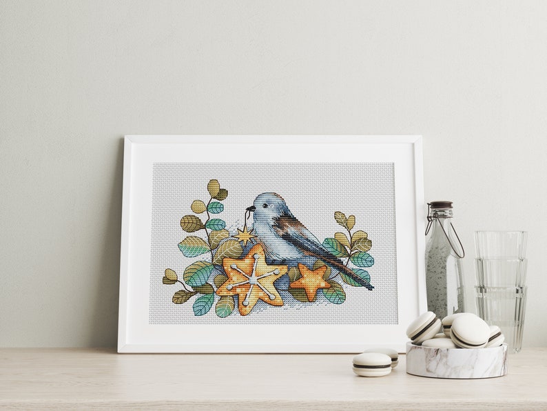 May include: A blue bird with a brown tail sits on a nest of star-shaped leaves. The bird is holding a small yellow star in its beak. The leaves are a mix of green and brown.