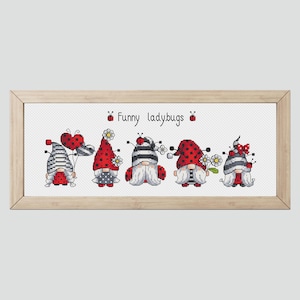 May include: Cross-stitch artwork showing five gnomes with ladybug-themed hats and outfits. The gnomes have white beards and hold flowers or balloons. The text "Funny ladybugs" is above the gnomes, all framed in a light wood frame.