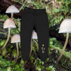 May include: Black sweatpants with a small graphic of three yellow mushrooms on the left leg.