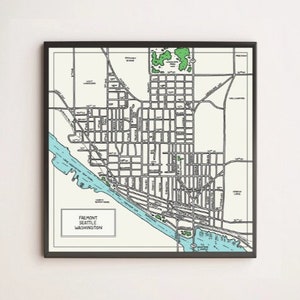 May include: A black and white map of Fremont, Seattle, Washington. The map shows the streets and waterways of the neighborhood. The map is framed in a black frame.