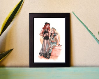 May include: A framed illustration of two people, a woman with red hair wearing a black dress and a man with blonde hair wearing a leather jacket, standing together against a peach-colored background.