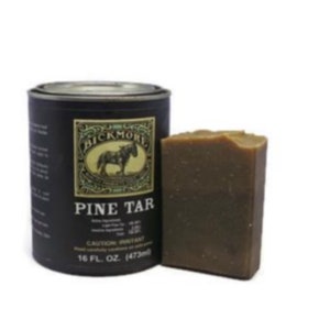 Può includere: Una lattina nera di catrame di pino Bickmore con una saponetta marrone accanto. La lattina ha un'etichetta con un cavallo e le parole "Bickmore Pine Tar" su di essa. La lattina è da 16 fl oz (473 ml).