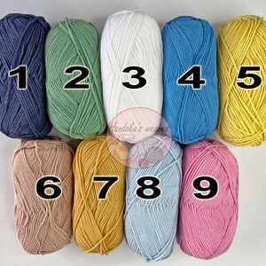 K&ouml;nnte beinhalten: Neun Garnkn&auml;uel in zwei Reihen angeordnet, nummeriert von eins bis neun. Die Farben umfassen Marineblau, Salbeigr&uuml;n, Wei&szlig;, Blau, Gelb, Beige, Senfgelb, Hellblau und Rosa. Ein kreisf&ouml;rmiges Logo mit dem Text Handoka's weaves ist zu sehen.
