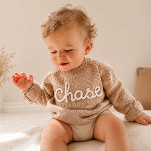 Beige personalized baby name sweater with custom knitted name “Chase”. Handmade knit baby jumper for newborns and toddlers, custom baby shower gift, neutral baby clothing.