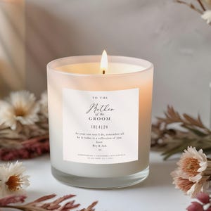 May include: A frosted glass candle with a lit wick and a white label reading: TO THE Mother of the GROOM 18|4|24 As your son says I do, remember all he is today is a reflection of you. Love Bry & Ash xx LEMONGRASS LAVENDER EUCALYPTUS soy wax candle 8oz | 240ml