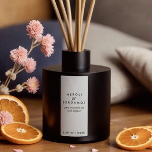 a bottle of reeds sitting next to an orange slice