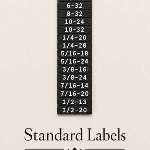 May include: A vertical stack of fourteen rectangular black labels with white text indicating thread sizes: 4-40, 6-32, 8-32, 10-24, 10-32, 1/4-20, 1/4-28, 5/16-18, 5/16-24, 3/8-16, 3/8-24, 7/16-14, 7/16-20, 1/2-13, and 1/2-20. Below the stack, the text reads Standard Labels.